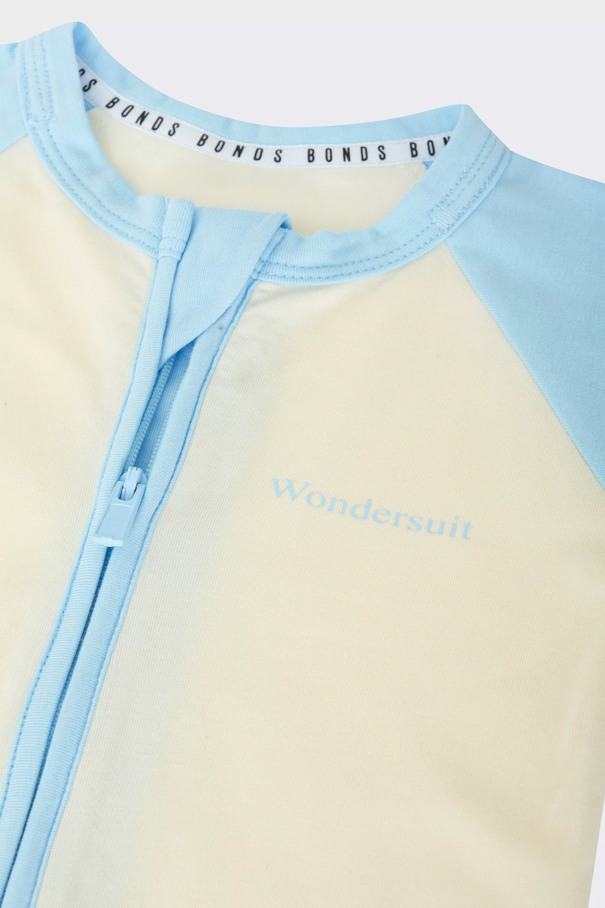 Bonds Everyday Value Zip Wondersuit baby sleepsuit in Levitating Airborne blue and cream. Close up two-way zip.