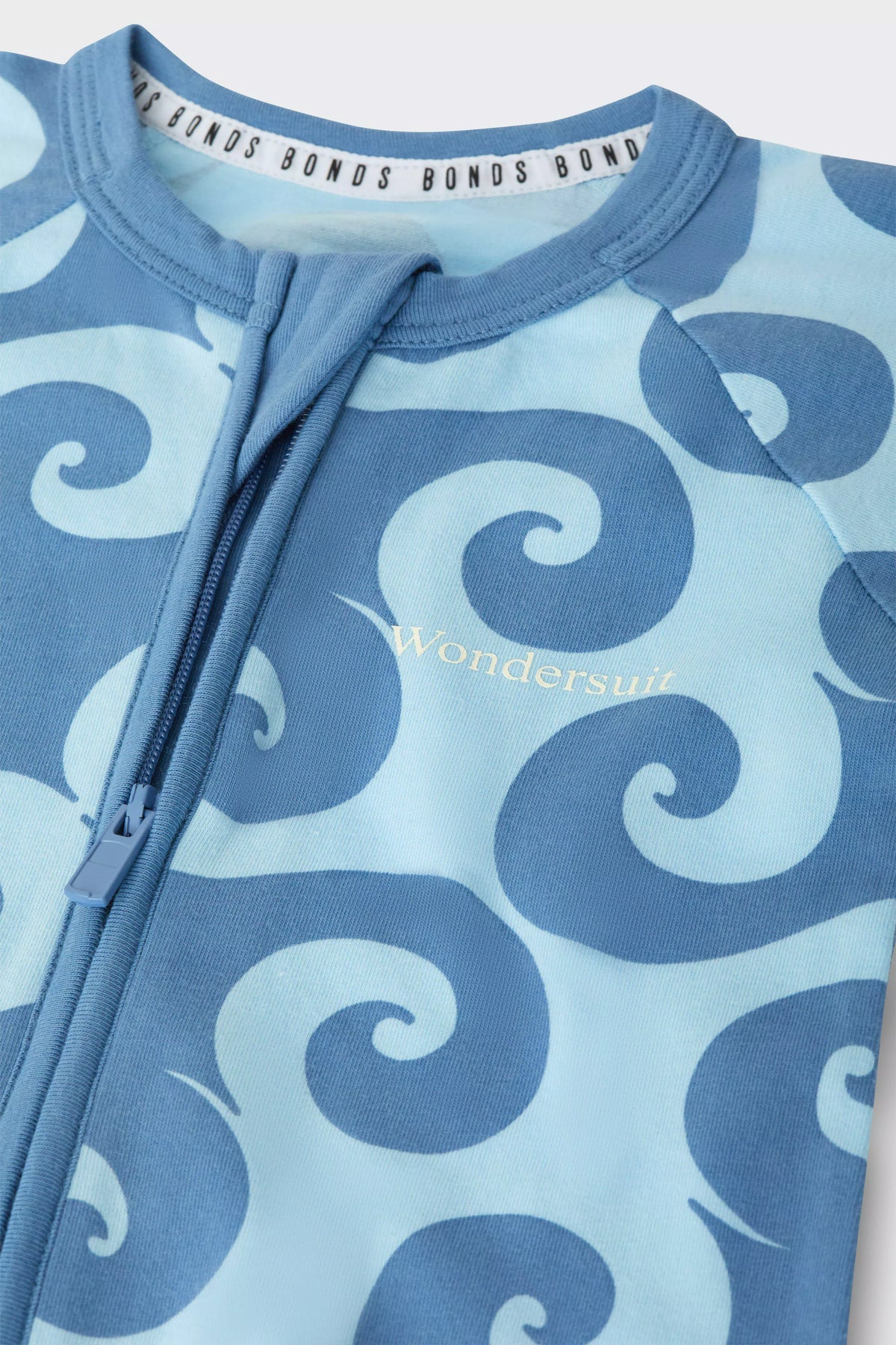 Bonds Zip Wondersuit baby sleepsuit in Wave Wonders blue wave swirl print. Close up two-way zip.