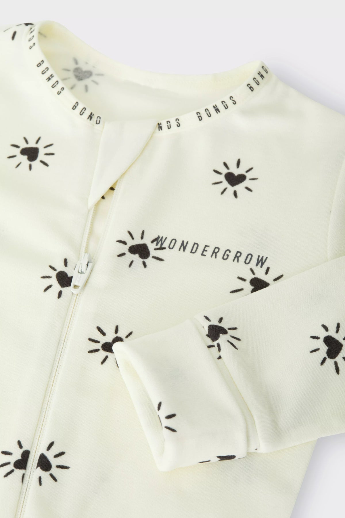 Bonds WonderGrow Zip Wondersuit bamboo baby sleepsuit in cream with black Sparkling Hearts. Close up of zip and rollable cuff.