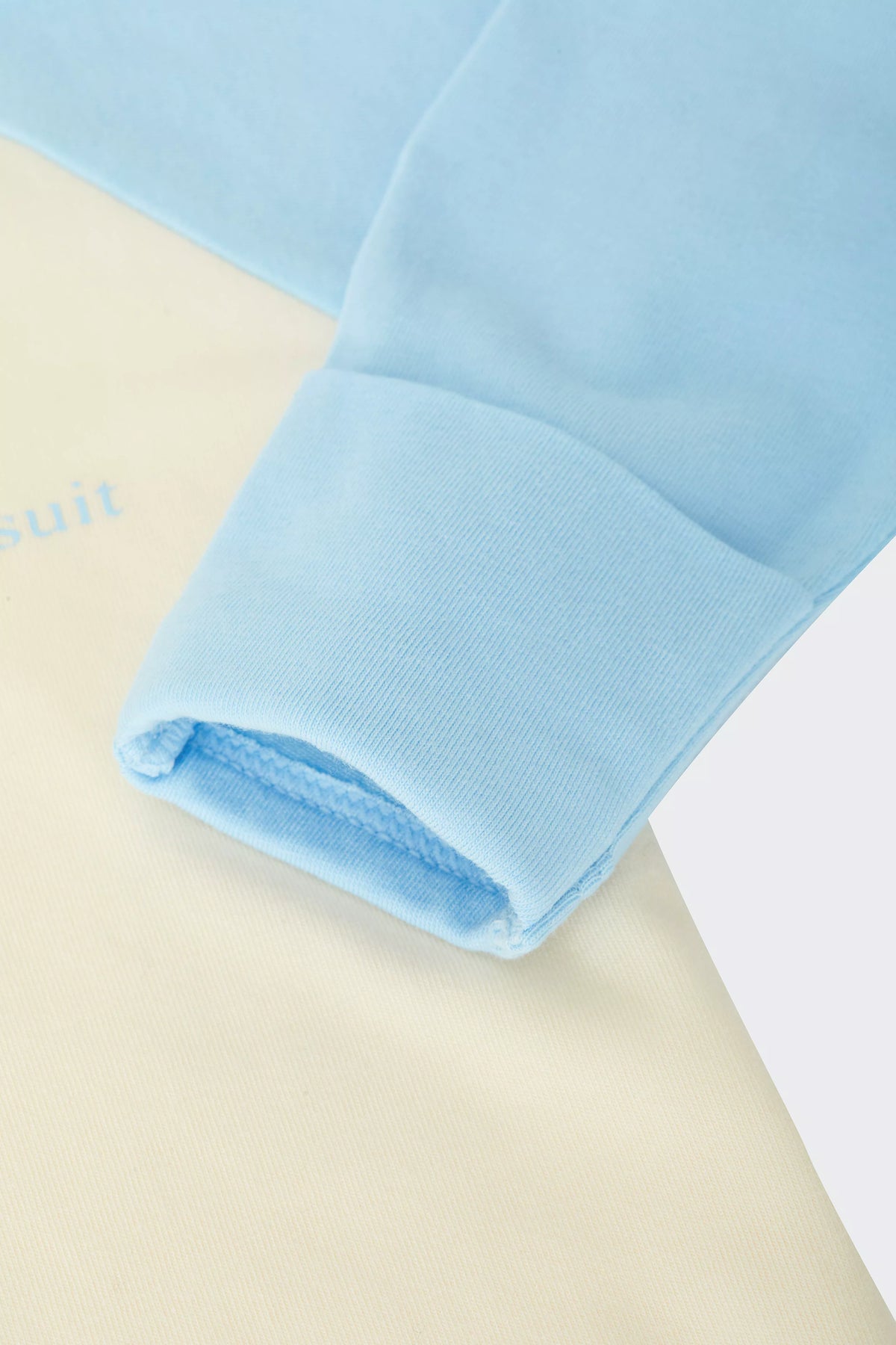 Bonds Everyday Value Zip Wondersuit baby sleepsuit in Levitating Airborne blue and cream. Close up hand cuff.