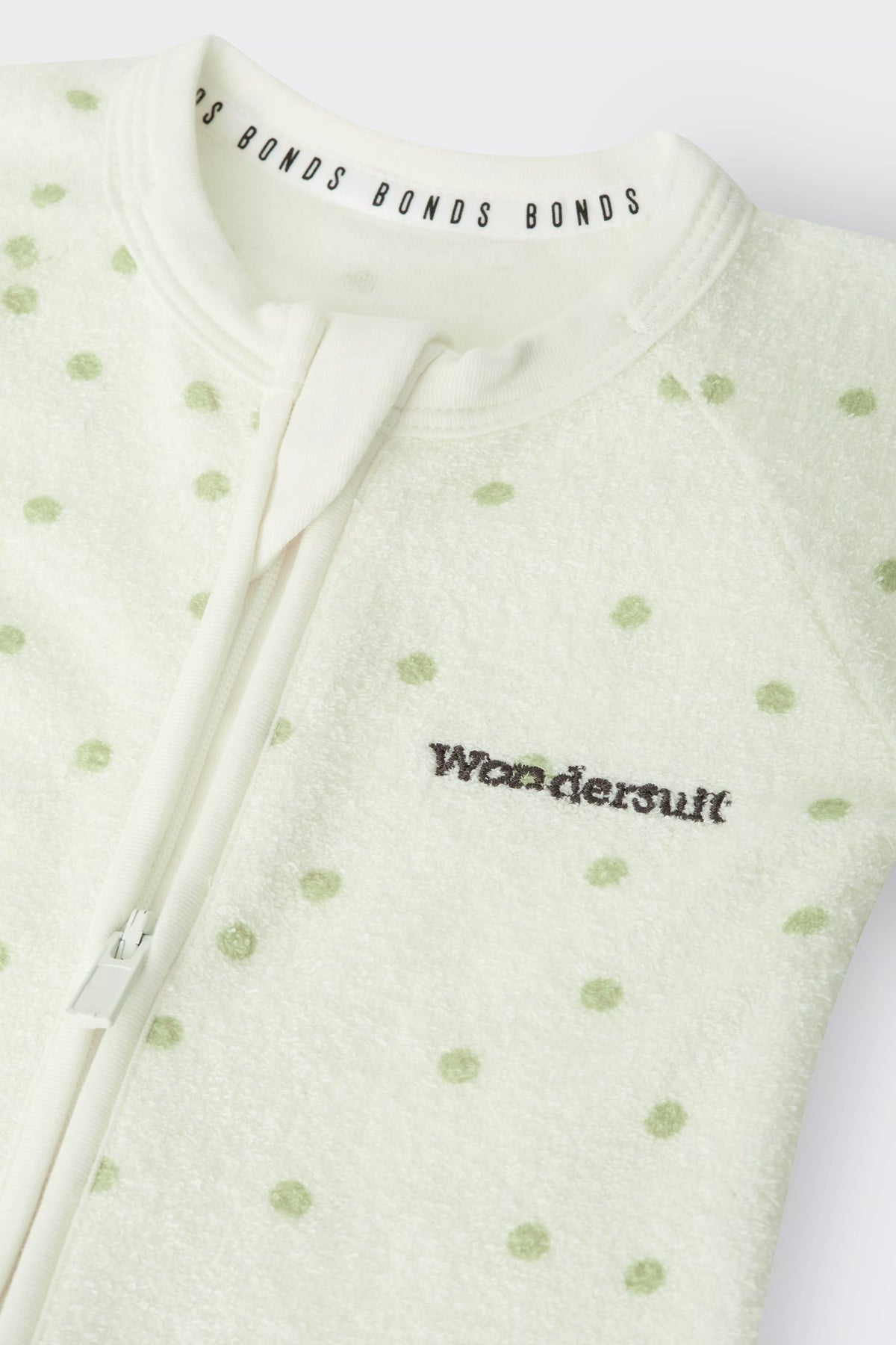 Bonds Poodlette Zip Wondersuit baby sleepsuit in Ditsy Dot Green polka dot print. Close up two-way zip.