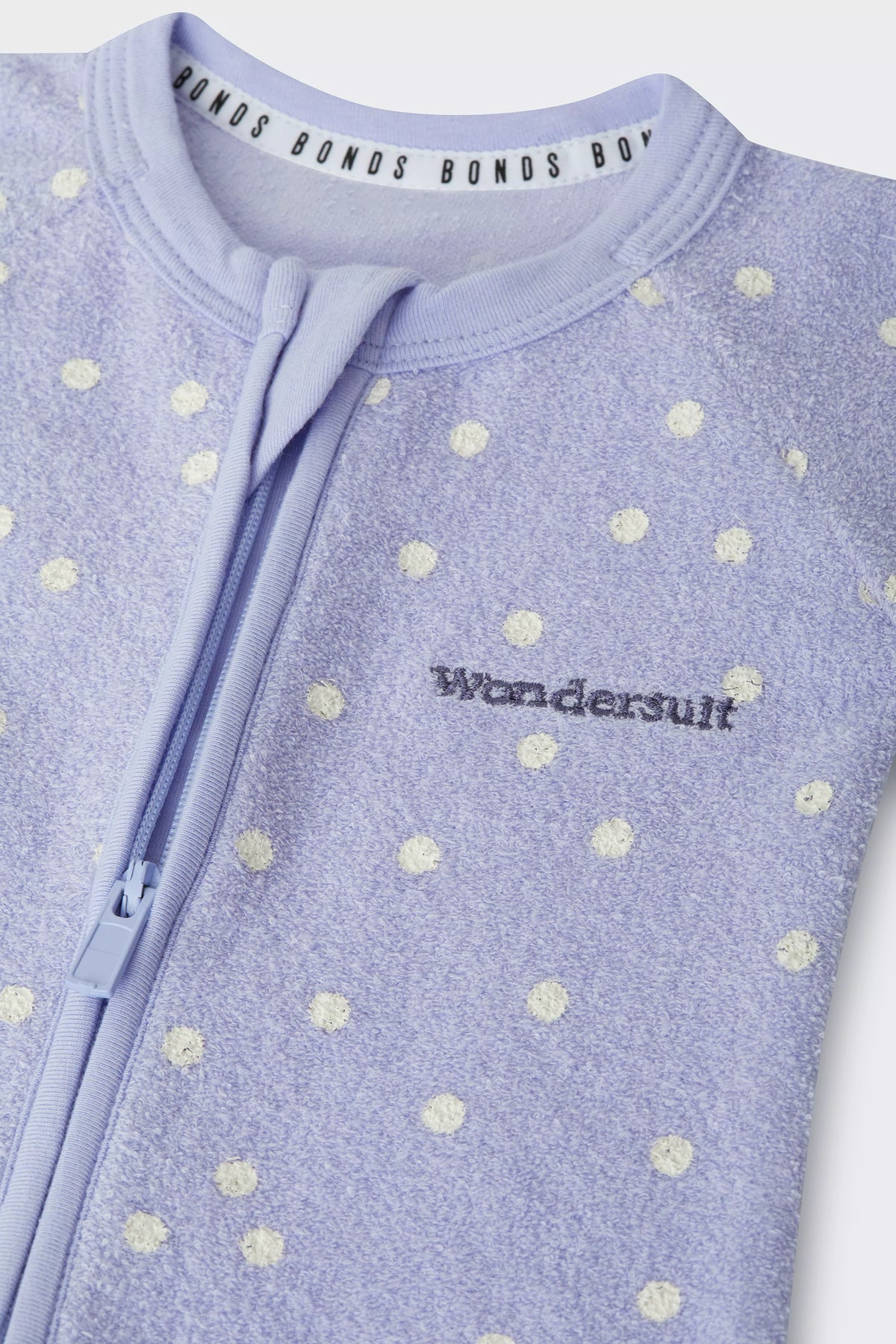 Bonds Poodlette Zip Wondersuit baby sleepsuit in Ditsy Dot Purple polka dot print. Close up Two-way zip.